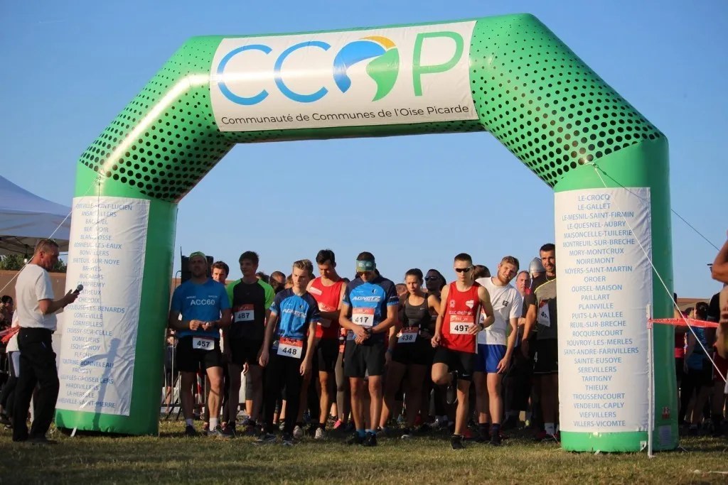 Arche gonflable verte CCOP installée au départ d'une course avec coureurs rassemblés