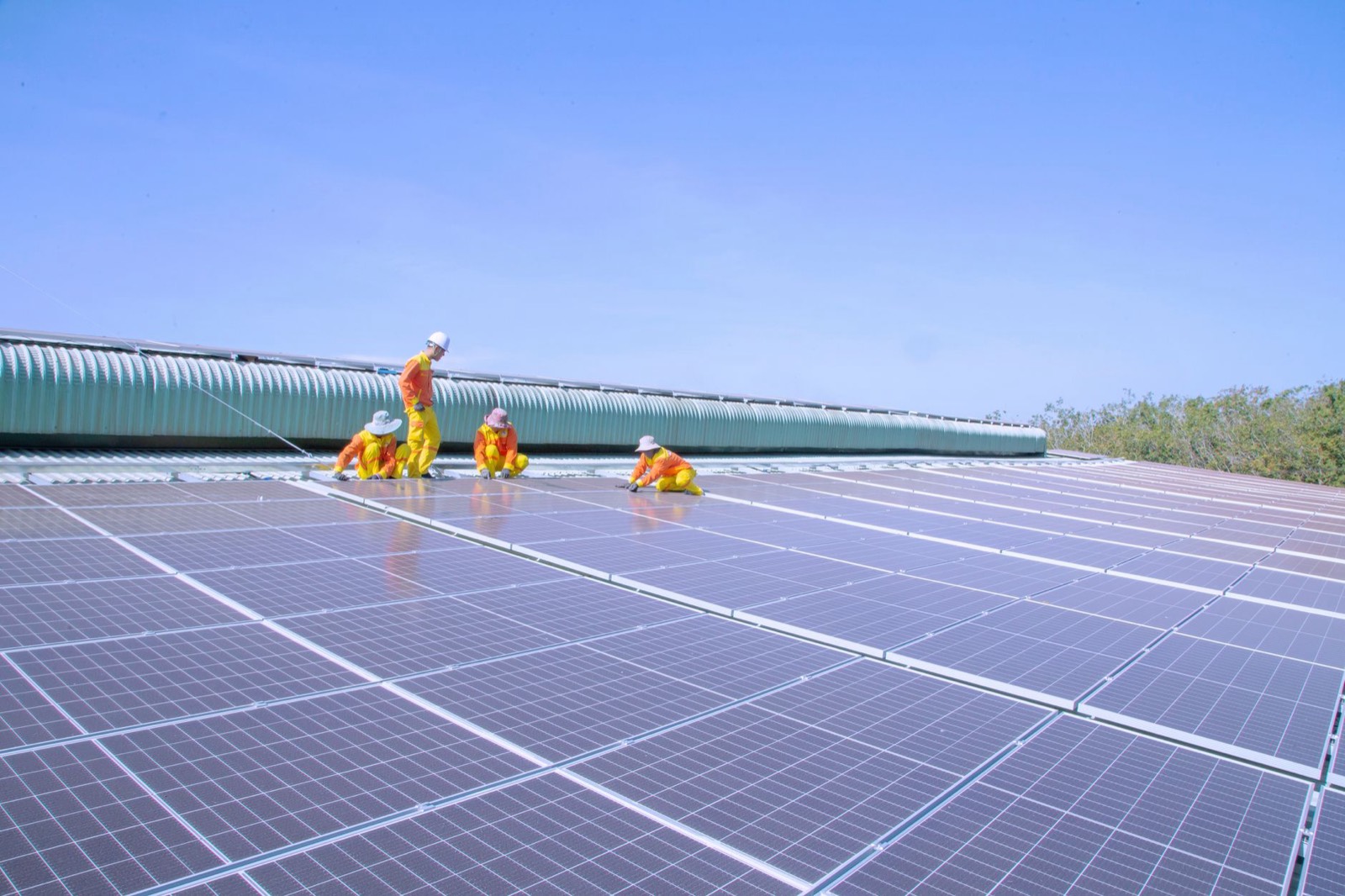 Deux techniciens installent des panneaux solaires sur un toit, illustration de l'investissement à impact