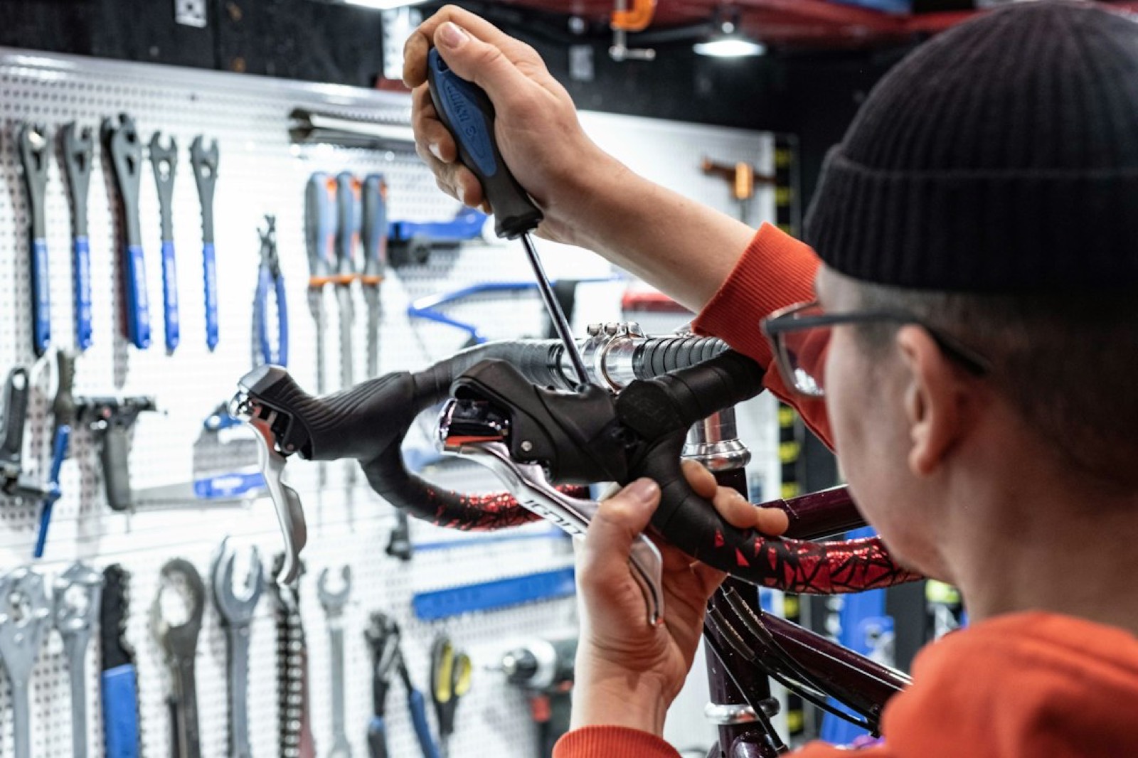 Cycliste ajustant la cale de sa chaussure de vélo avec un tournevis