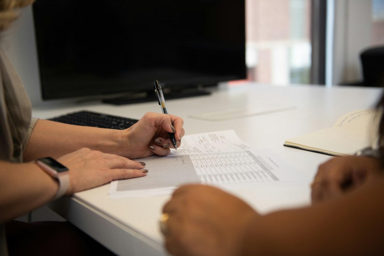 Deux personnes signant un accord de médiation sur une table