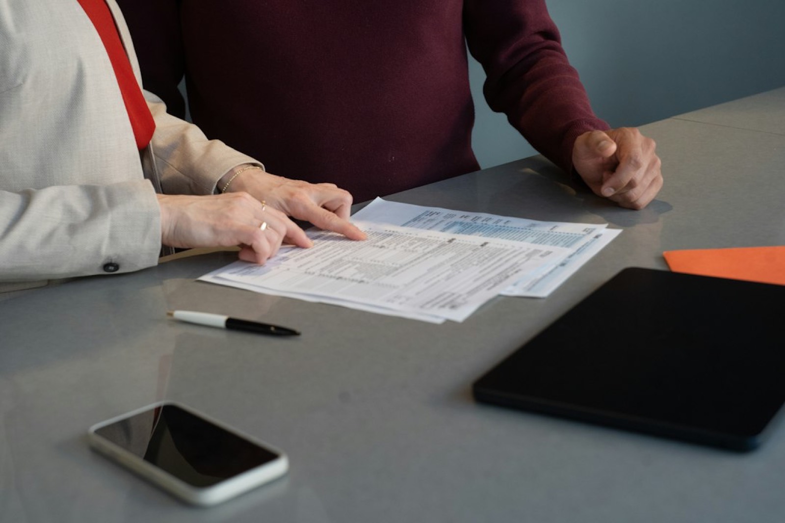 Personne qui lit un contrat financier avant de signer un investissement à impact social